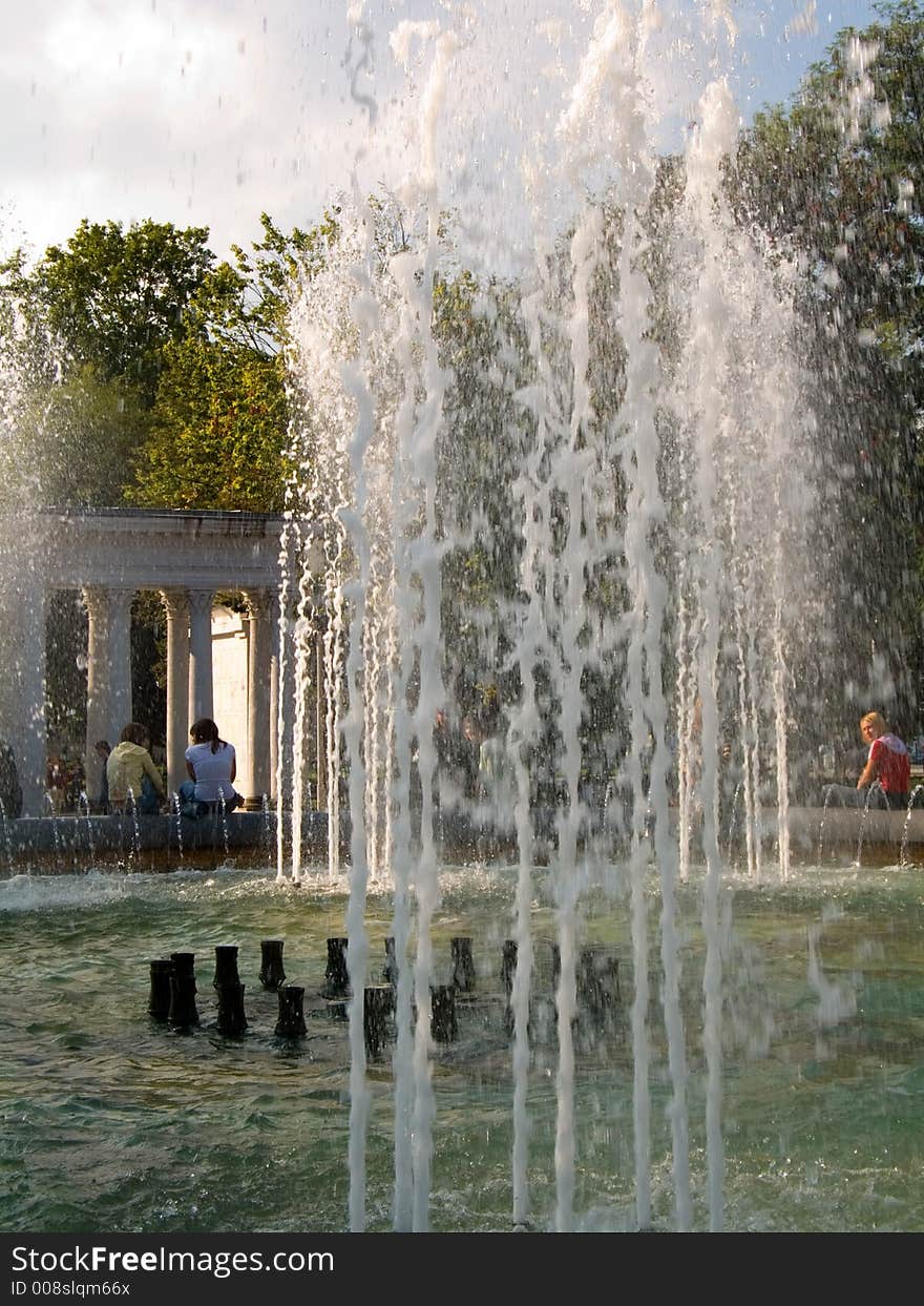 Sheets of water in the fountain, people resting