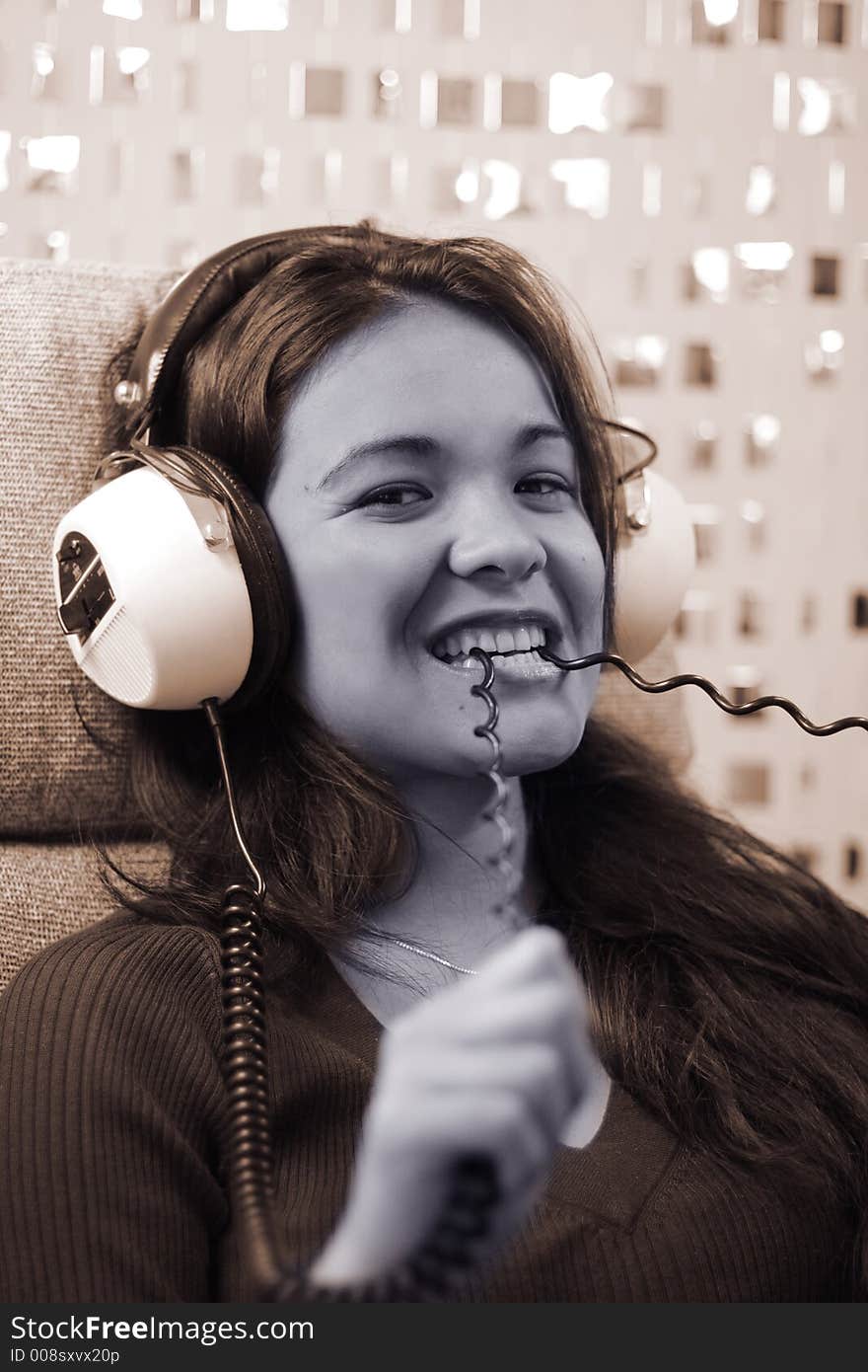 Beautiful young woman listening to music and biting headphone cord. Beautiful young woman listening to music and biting headphone cord