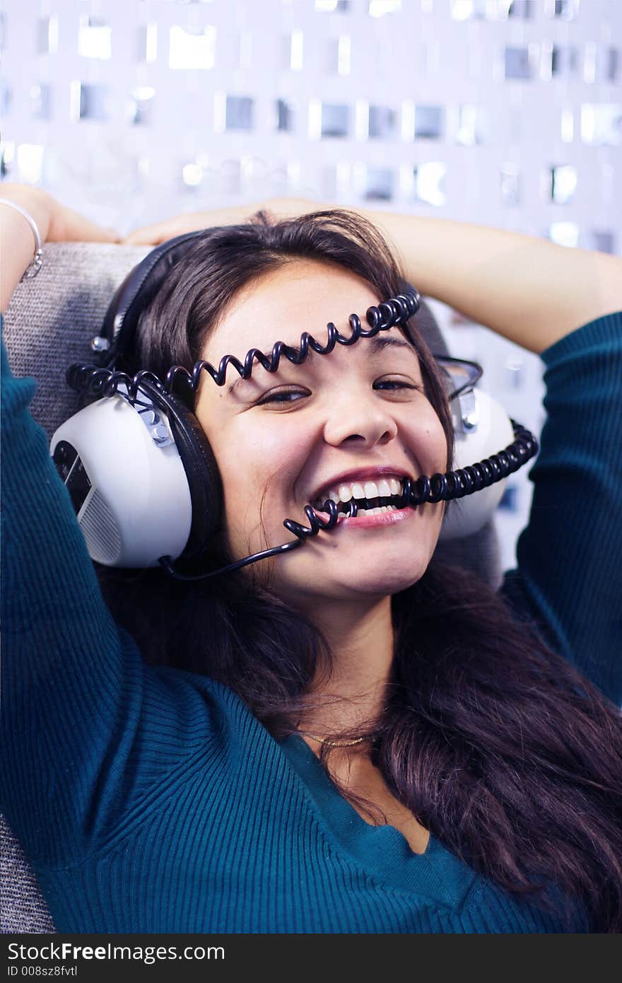 Beautiful young woman listening to music and biting headphone coil. Beautiful young woman listening to music and biting headphone coil