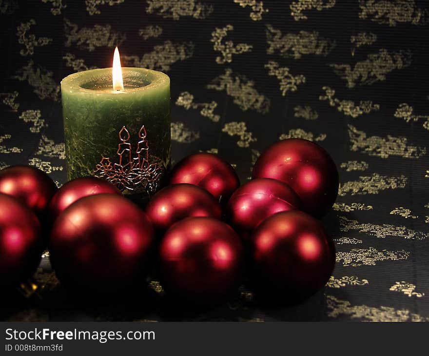 Detail green christmas candle on blue decorated background  and red balls