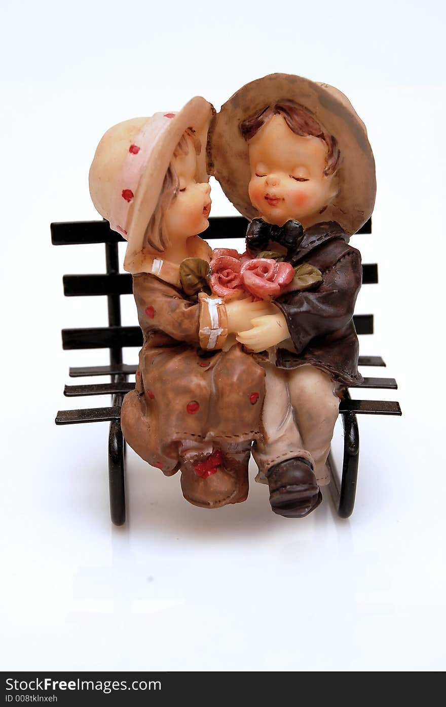 Figurine of boy and girl sitting on a bench. Figurine of boy and girl sitting on a bench