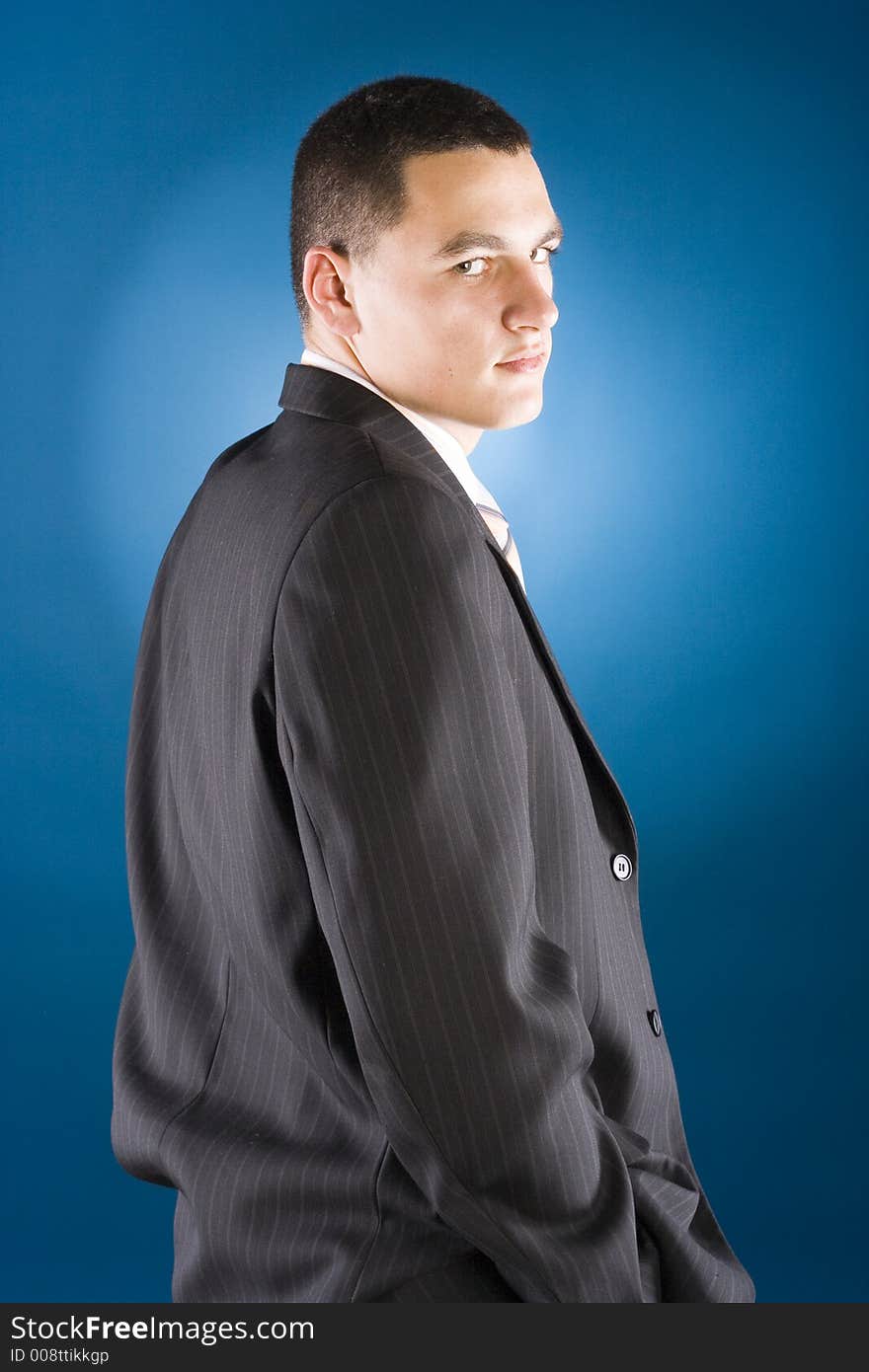 Young businessman standing (blue background)