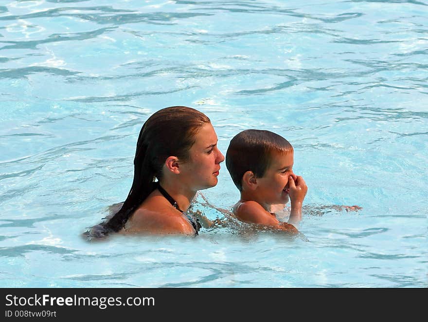 Older sibling helping younger to swim. Older sibling helping younger to swim