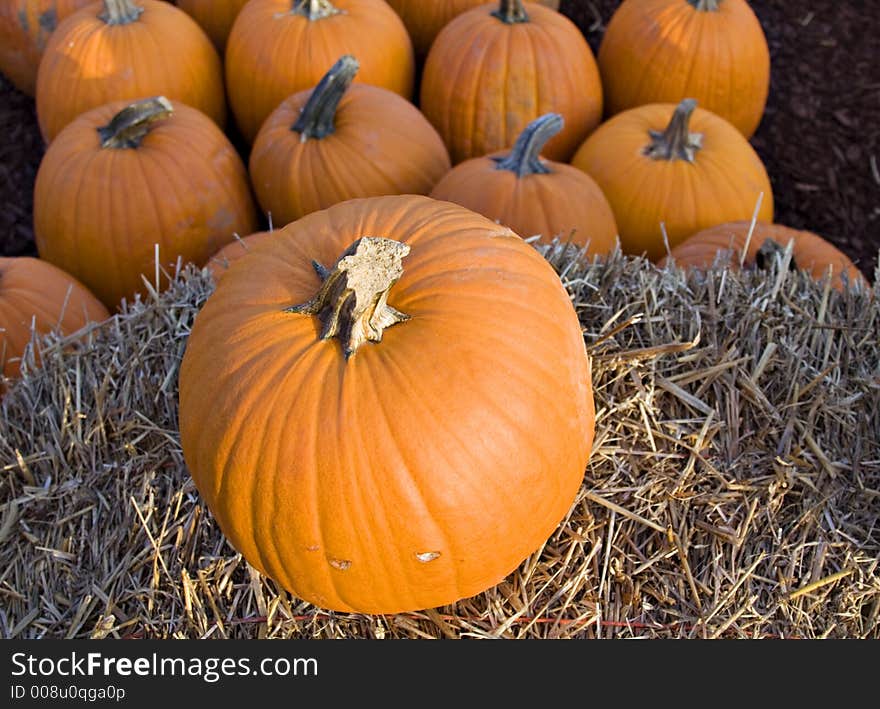 Pumpkins sitting on and around ahay bale. Pumpkins sitting on and around ahay bale.