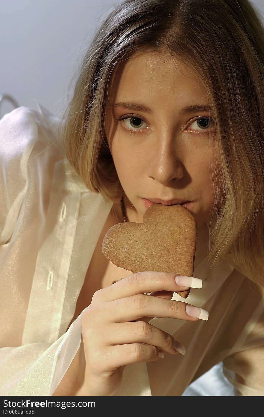 Blond girl, young woman with a ginger bread heart. Blond girl, young woman with a ginger bread heart