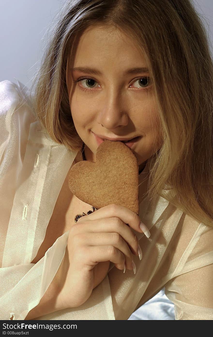 Blond girl, young woman with a ginger bread heart. Blond girl, young woman with a ginger bread heart