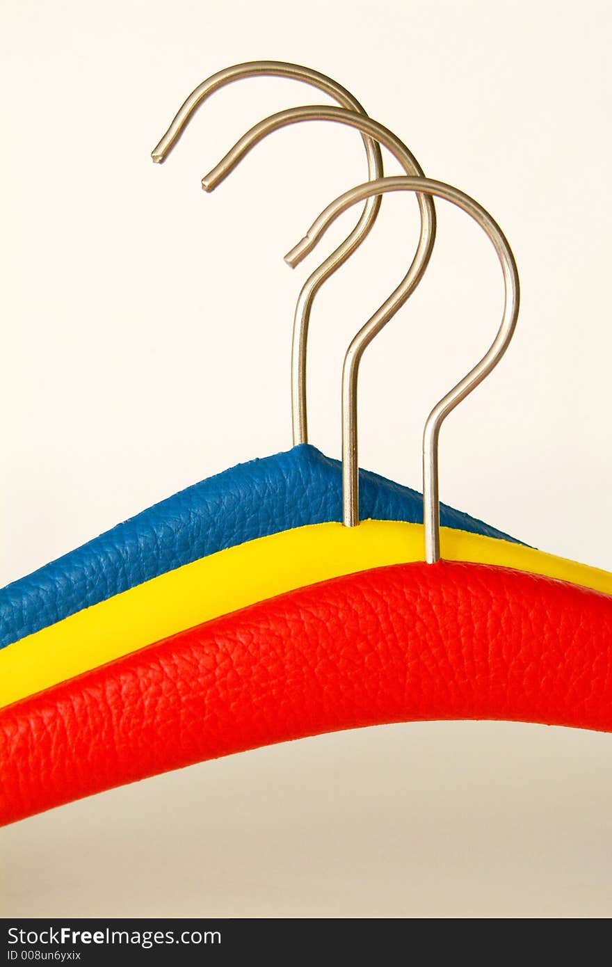 Multi-coloured coathangers on the white background