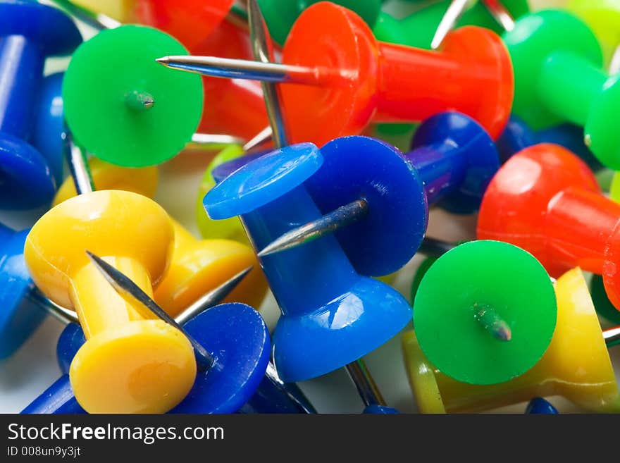 Colored pins from above on a white background