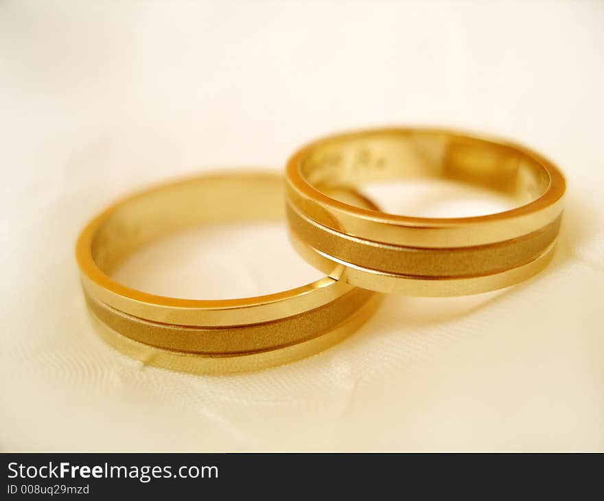 Two wedding rings on the off-white background