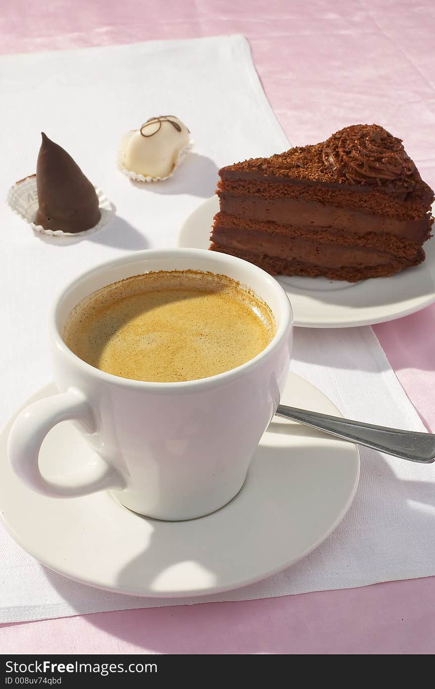 A cup of coffee and a piece of chocolate cake on white background. A cup of coffee and a piece of chocolate cake on white background