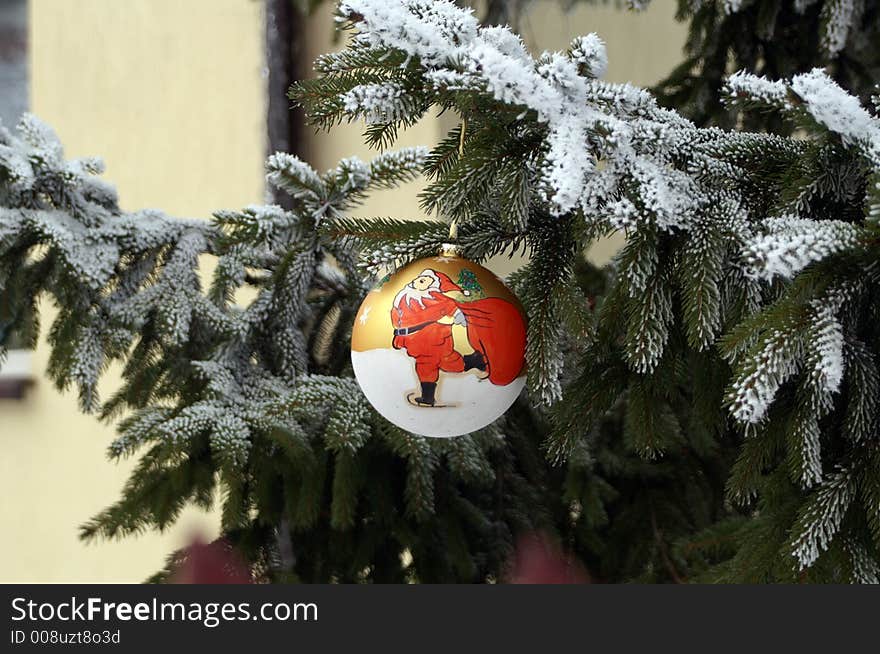 Christmas decoration - glass ball on spruce with snow-