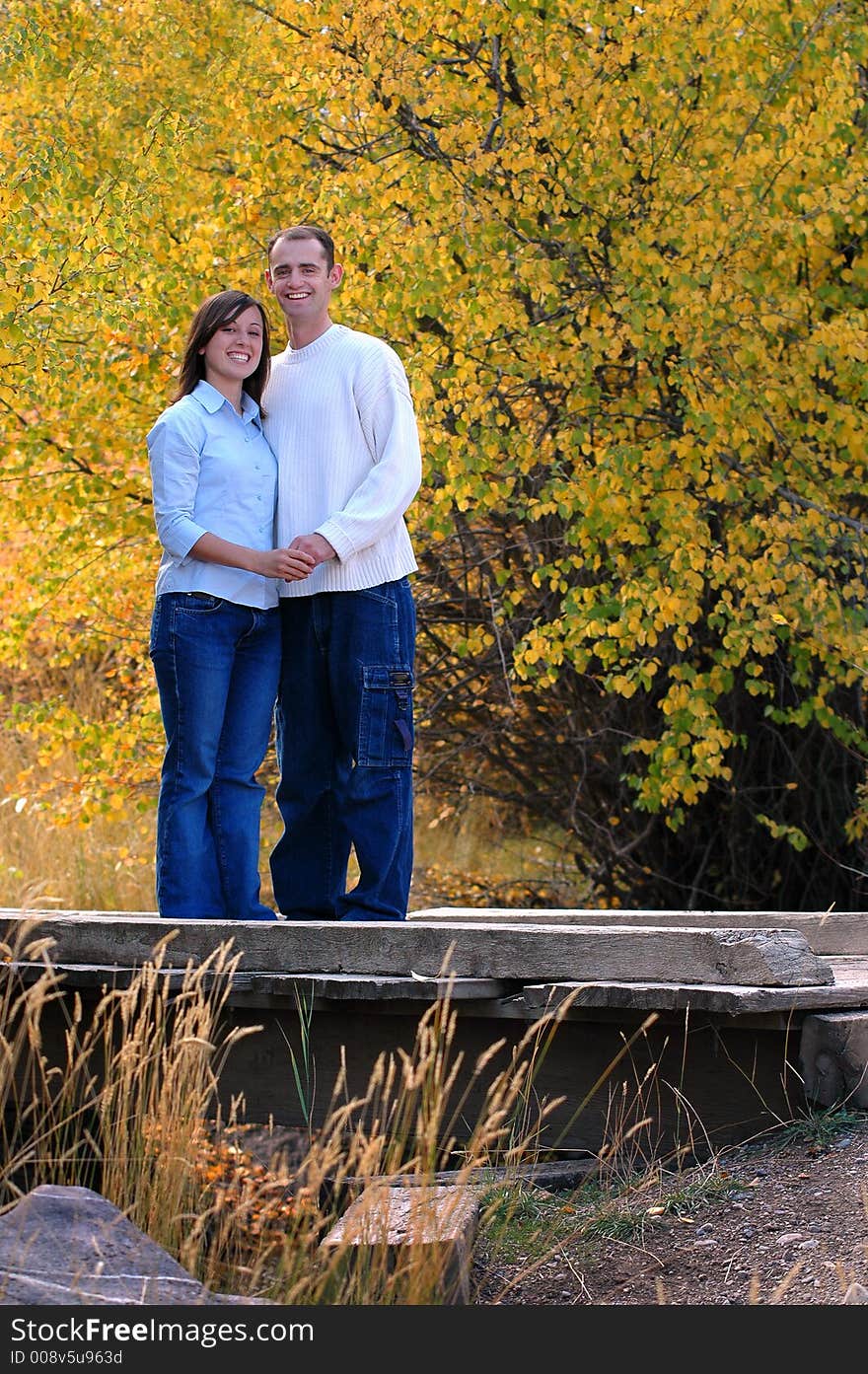 Couple portrait hugging and laughing with trees behind