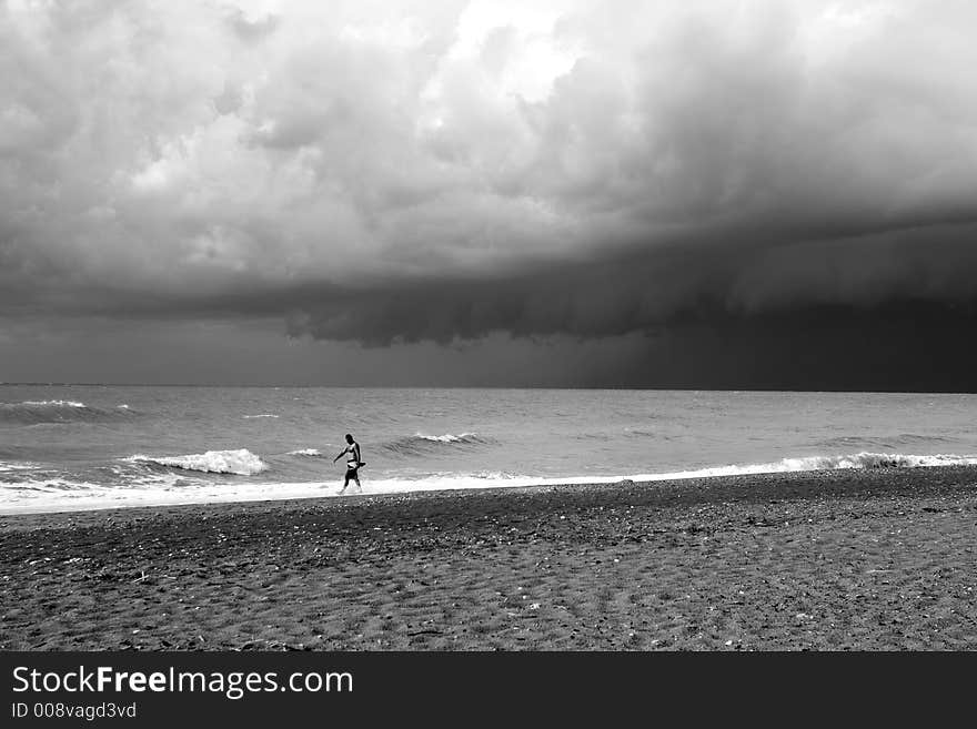 A lone swimmer on a stormy day, with dramatic sky.Black and White. A lone swimmer on a stormy day, with dramatic sky.Black and White.