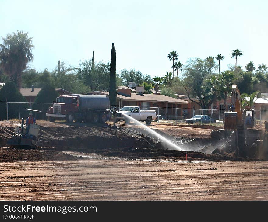 Trucks and workers digging and prepairing the ground for a house and construction site. Trucks and workers digging and prepairing the ground for a house and construction site.