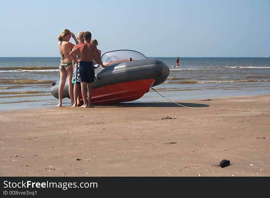 A speedboat with 4 children on the beach with the sea on the horizon. A speedboat with 4 children on the beach with the sea on the horizon.