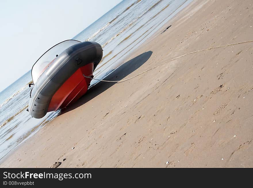 A speedboat/motorboat on the beach with the sea on the horizon. Picture taken on a 45degree angle