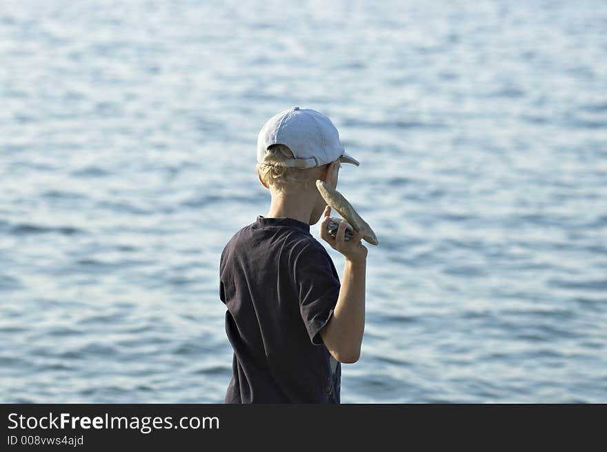 The child plays on a stone beach. The child plays on a stone beach