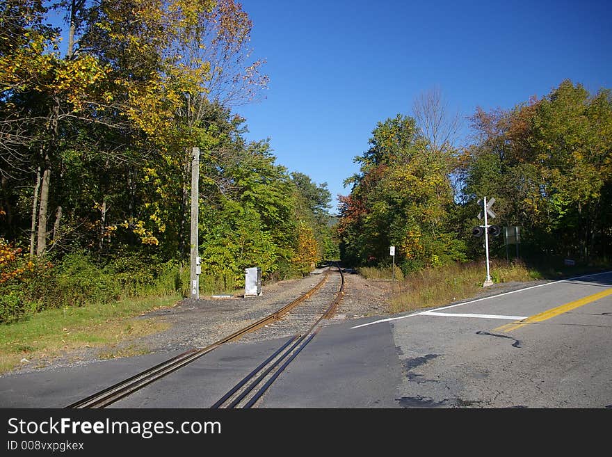 This is a typical, reflective, rural rail road metal crossing sign mounted on a pole found at a remote road crossing. This is a typical, reflective, rural rail road metal crossing sign mounted on a pole found at a remote road crossing.