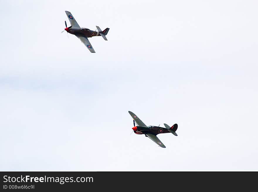 A P40 Kittyhawk and a CA-18 fly past during an air show. A P40 Kittyhawk and a CA-18 fly past during an air show.