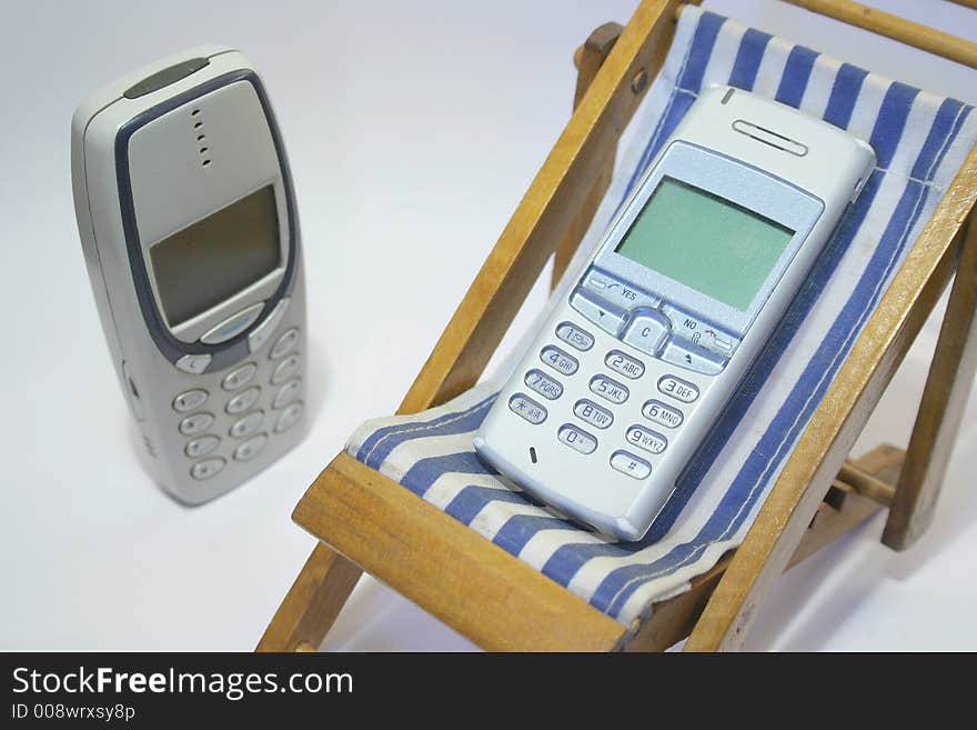 Cell phone in the relaxing chair with blue stripes. Cell phone in the relaxing chair with blue stripes