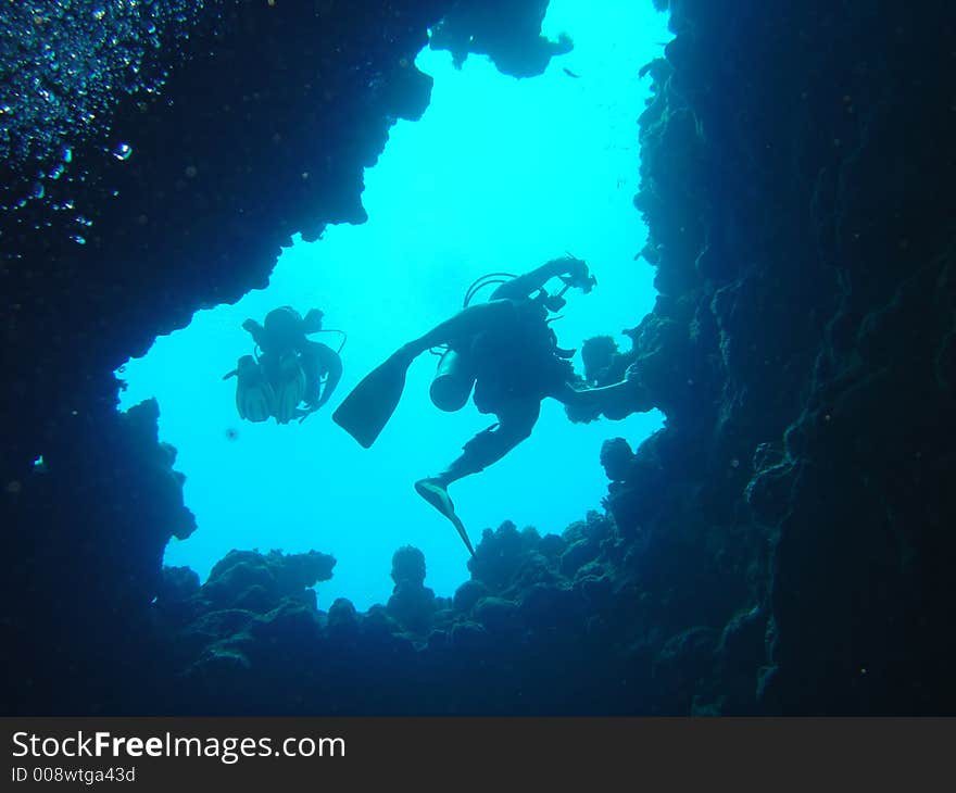 Divers ascending towards the light. Divers ascending towards the light