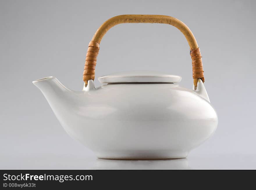 White kettle with straw hand isolated on white