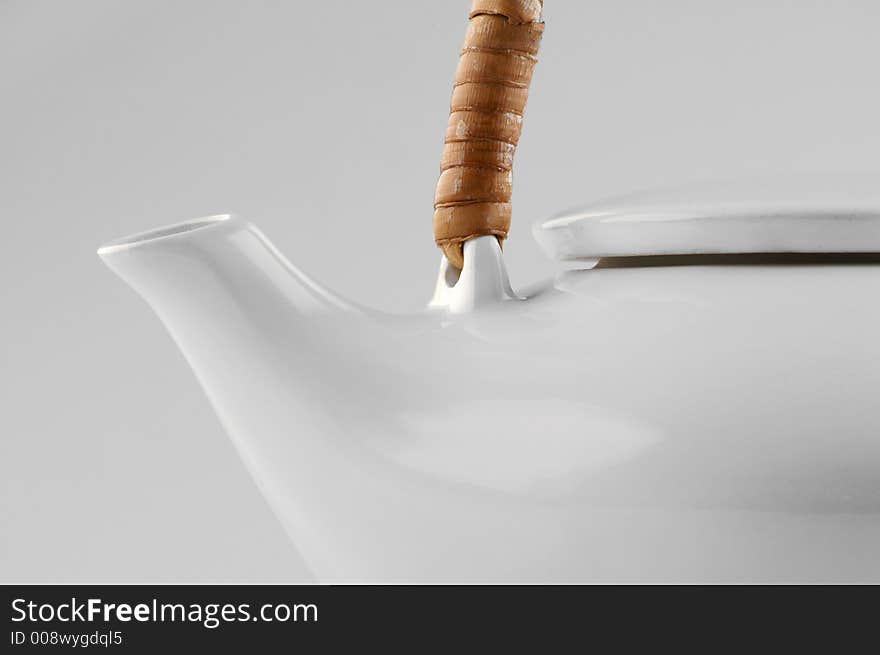 White kettle with straw hand isolated on white close-up