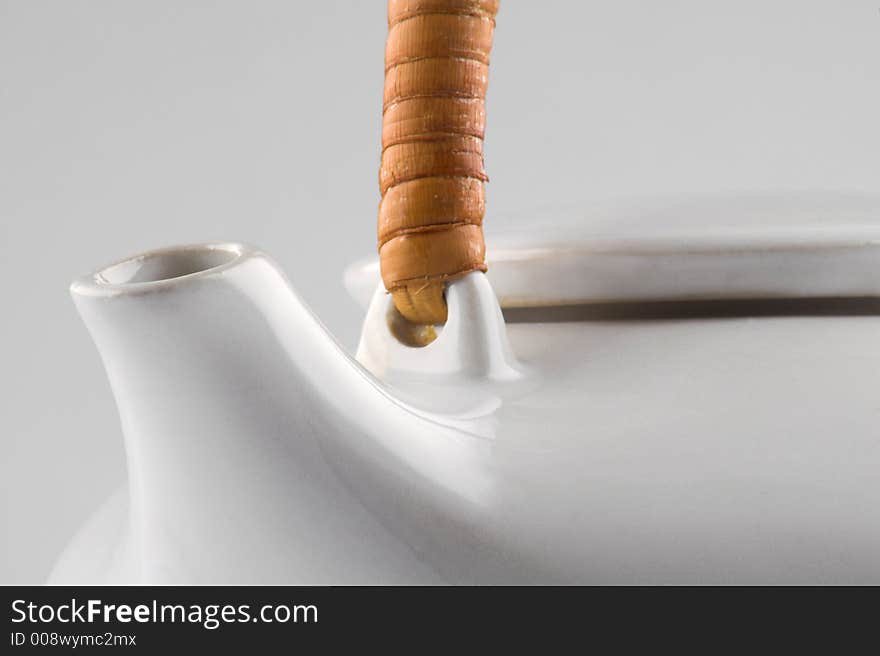 White kettle with straw hand isolated on white close-up