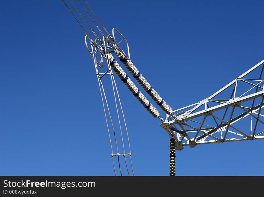 Part of super high voltage power pylon in blue sky.