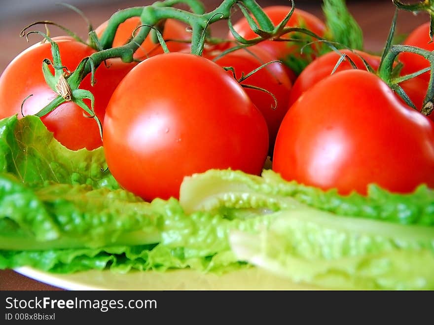 A bunch of lovely red fresh tomatoes in focus. A bunch of lovely red fresh tomatoes in focus