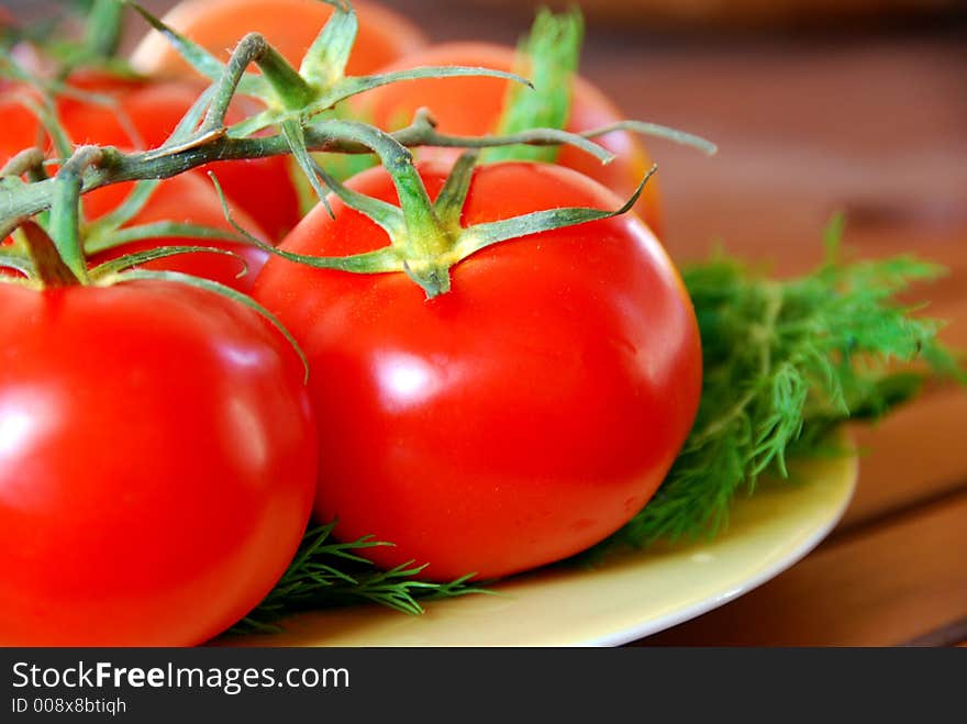 A bunch of lovely red fresh tomatoes in focus. A bunch of lovely red fresh tomatoes in focus