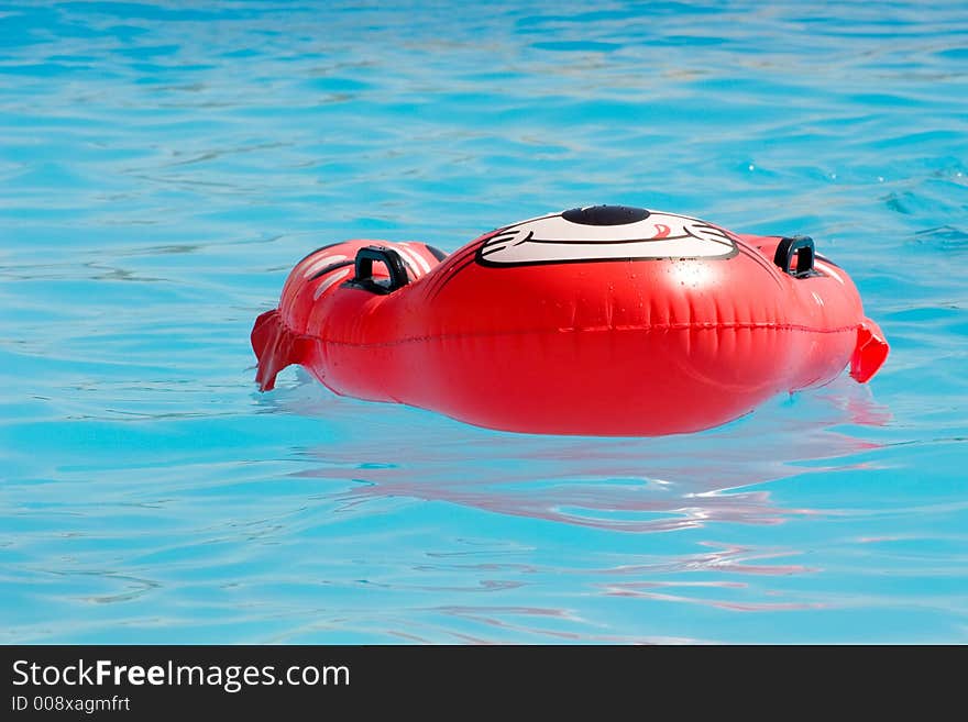 Red rubber ring floating in a swimmin pool. Red rubber ring floating in a swimmin pool