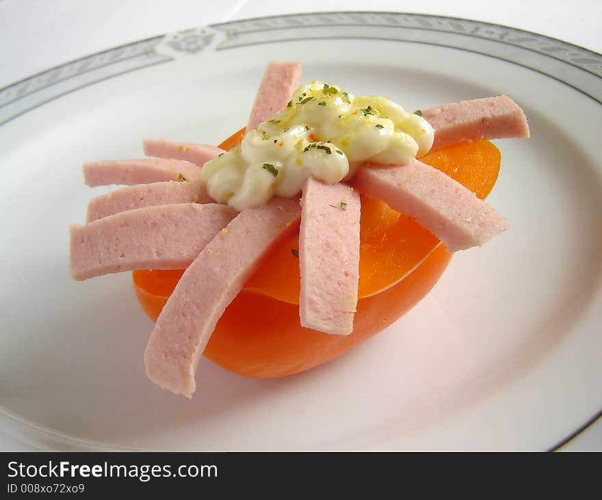 Gourmet dish with orange paprika and salami, decorated with mayonnaise dressing. Gourmet dish with orange paprika and salami, decorated with mayonnaise dressing