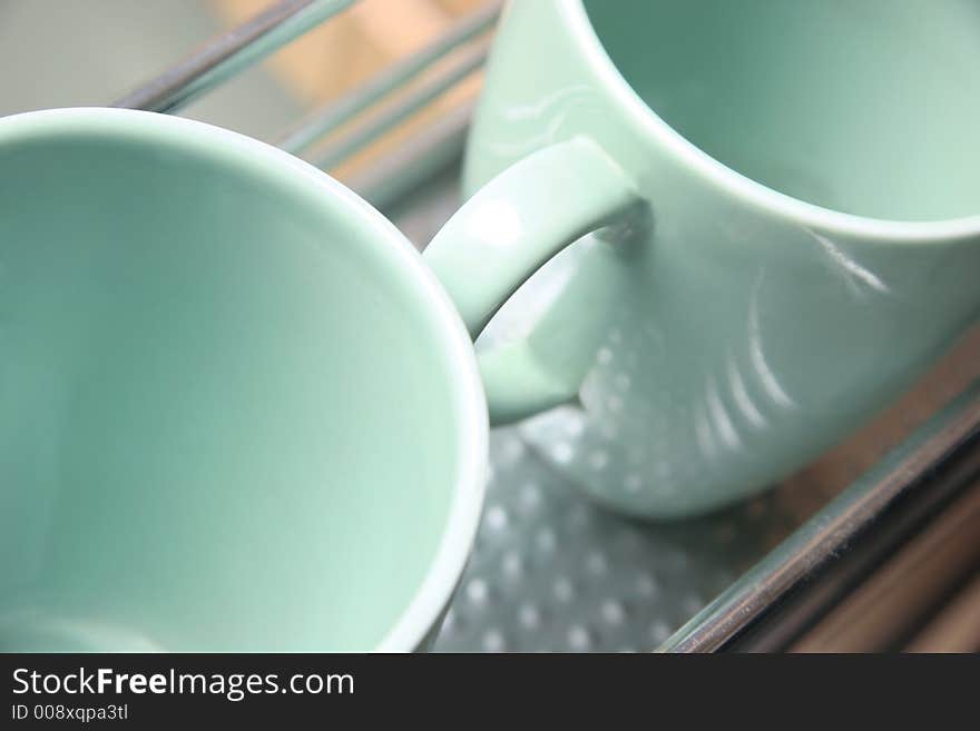 Two green cups on a iron shelf. Two green cups on a iron shelf.