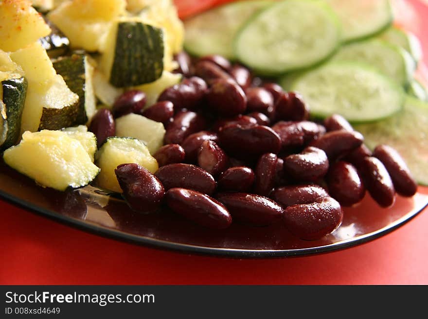 Vegetarian dish. Beans, fried marrows, fresh tomatoes and cucumbers.