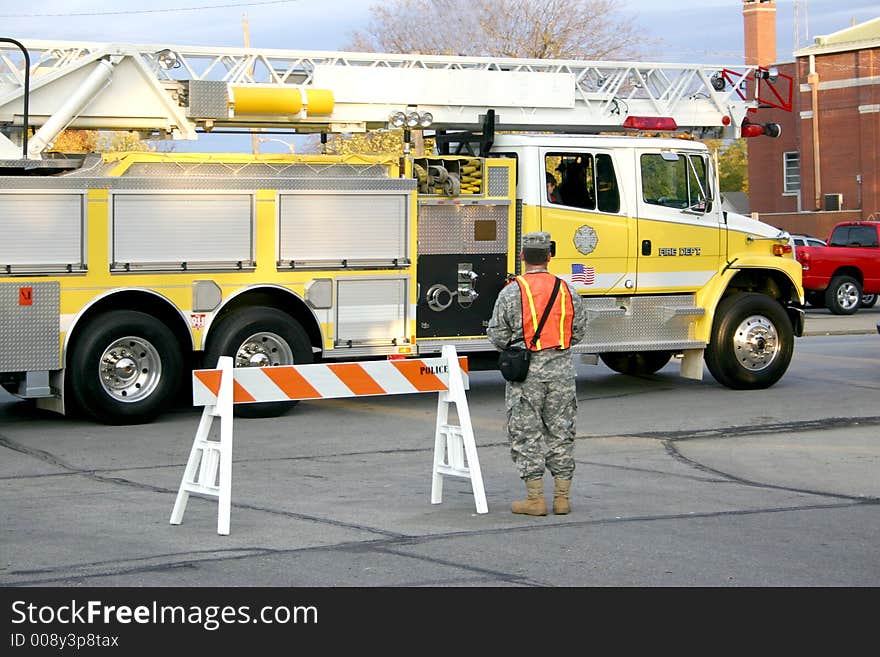 A firetruck responds to an emergency while a national guardsman blocks traffic. A firetruck responds to an emergency while a national guardsman blocks traffic.