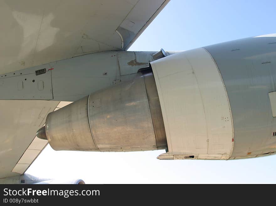 Detail of a jet turbine attached to a wing of a big passenger aircraft