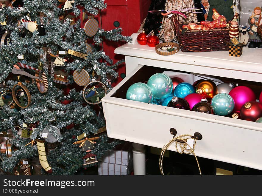 Cropped shot of a decorated christmas tree and to the right a dresser filled with christmas ornaments. Cropped shot of a decorated christmas tree and to the right a dresser filled with christmas ornaments