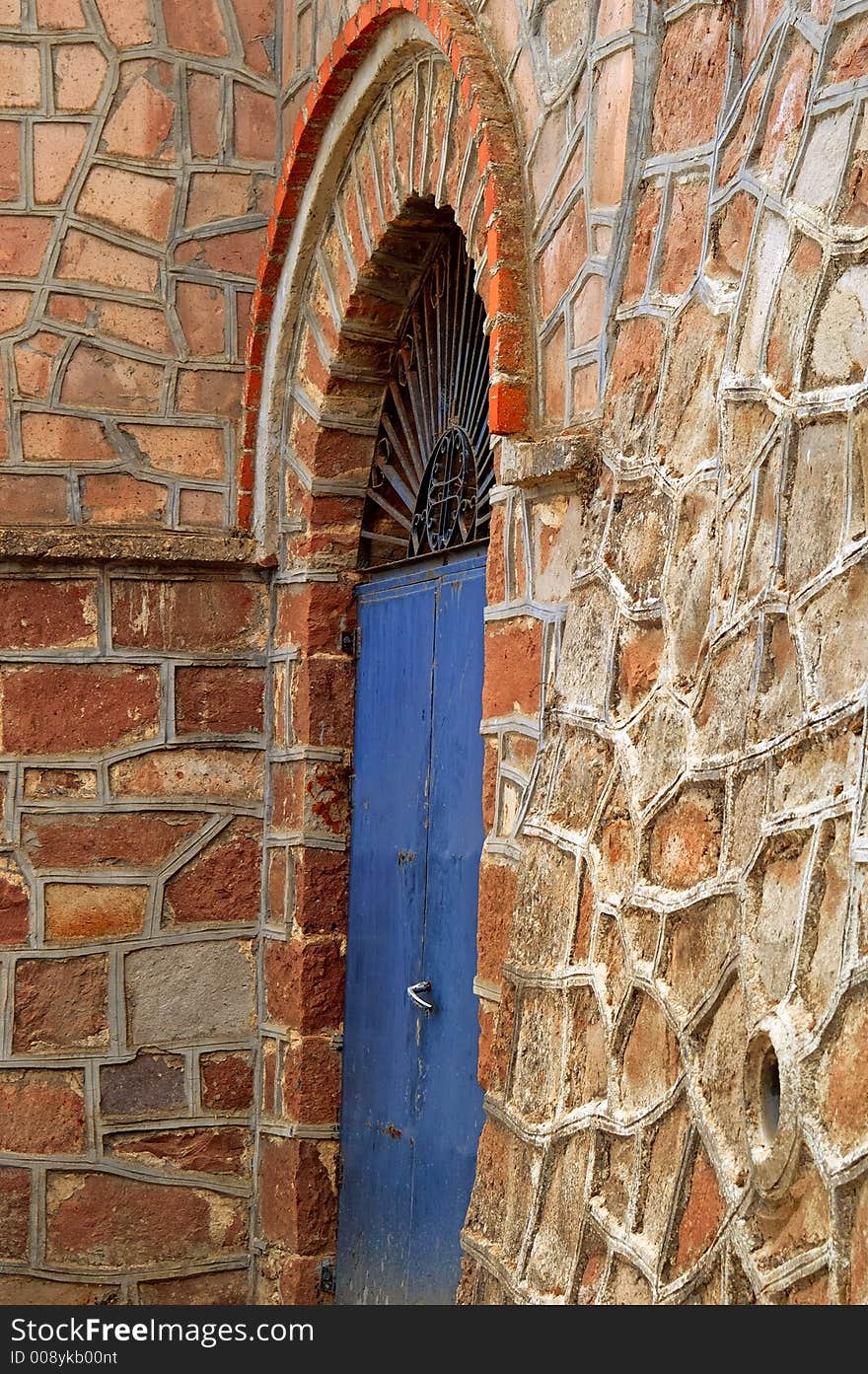 A traditional  blue door in stone brown wall in greece. A traditional  blue door in stone brown wall in greece