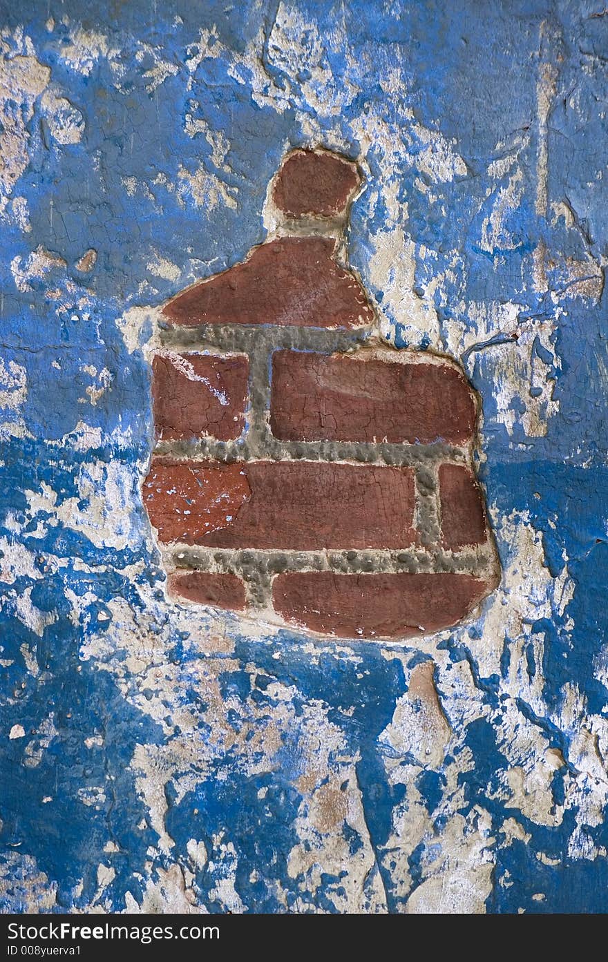 Exposed brick in a blue painted stucco wall