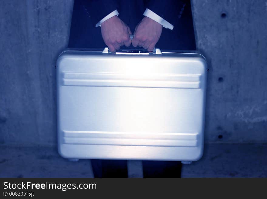 Businessman holds his briefcase in front of his body for security. Businessman holds his briefcase in front of his body for security