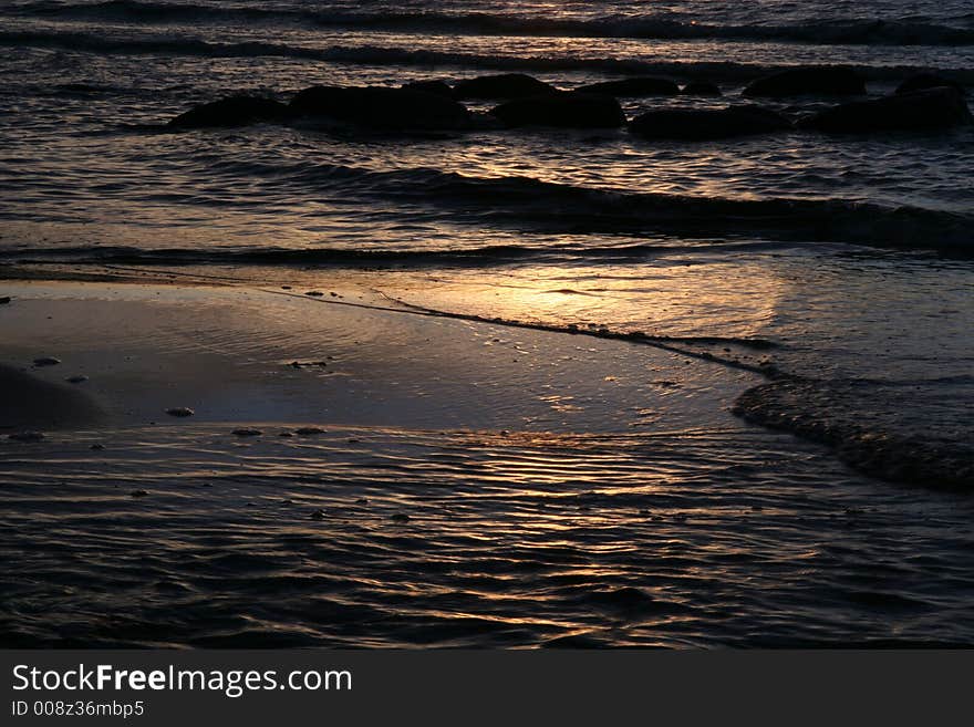 Waves and stones at sunset