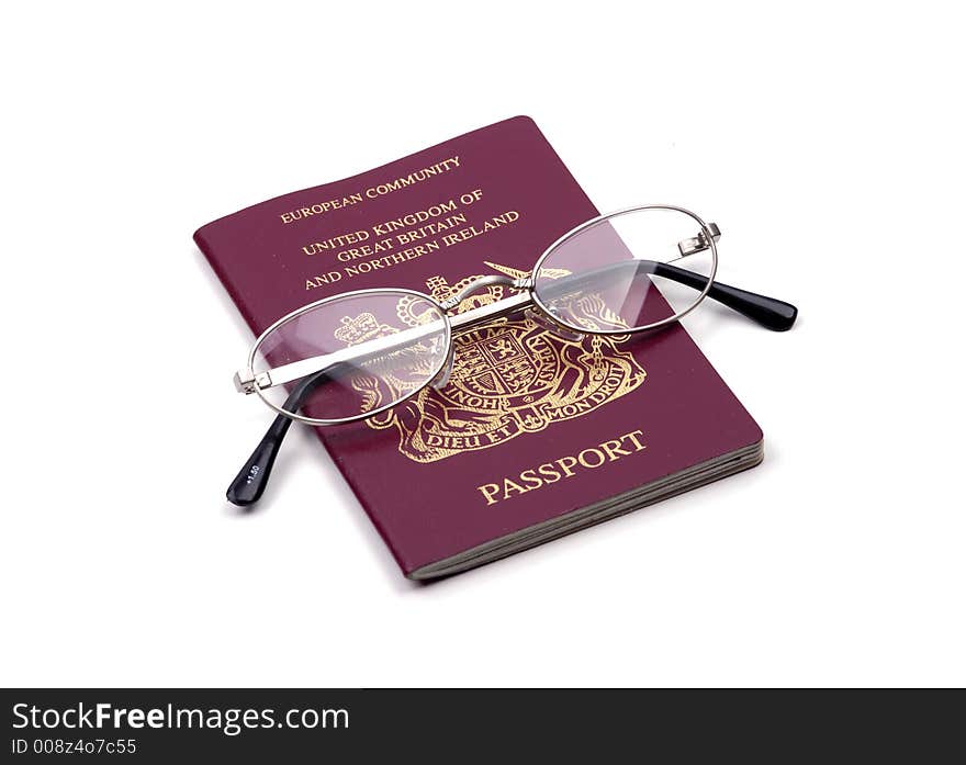 A British passport and glasses isolated against a white background. A British passport and glasses isolated against a white background.