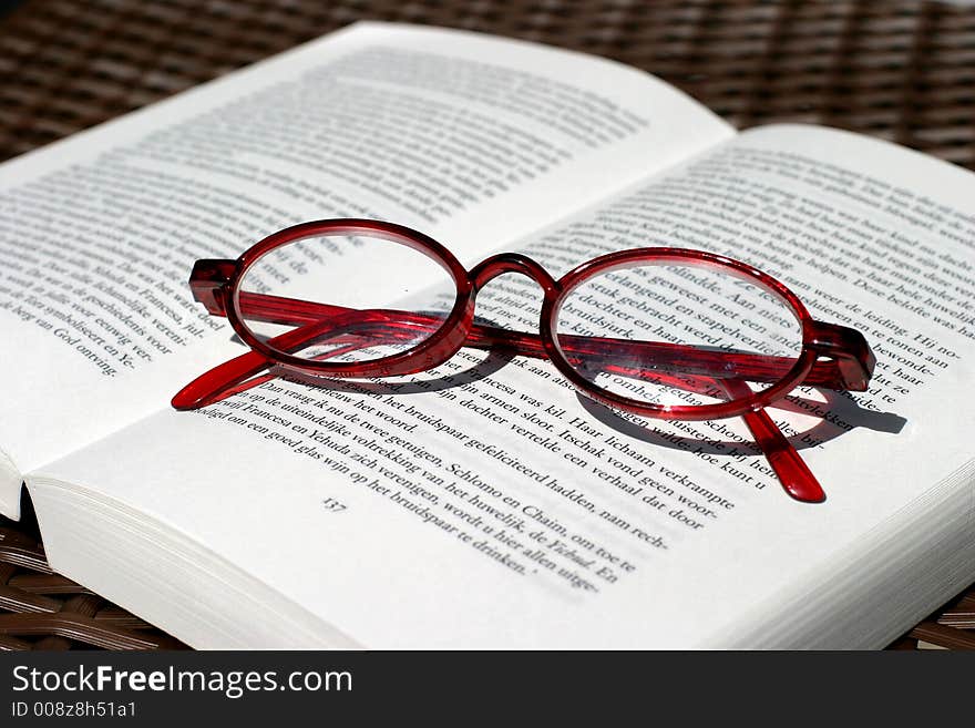 Red reading glasses and book. Red reading glasses and book