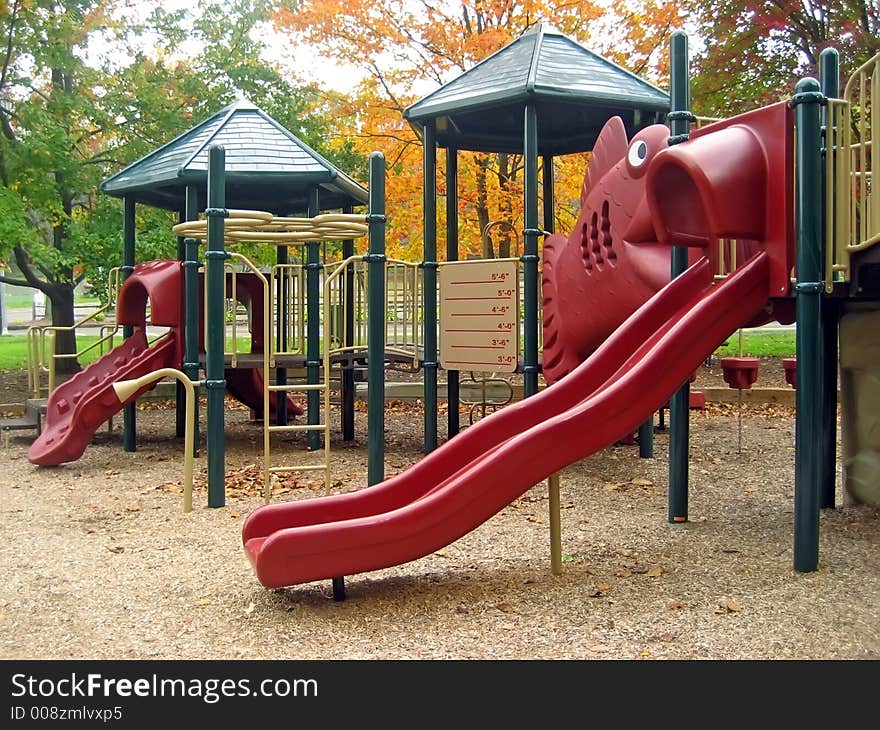 Playground in Autumn with Two Red Sliding Boards. Playground in Autumn with Two Red Sliding Boards