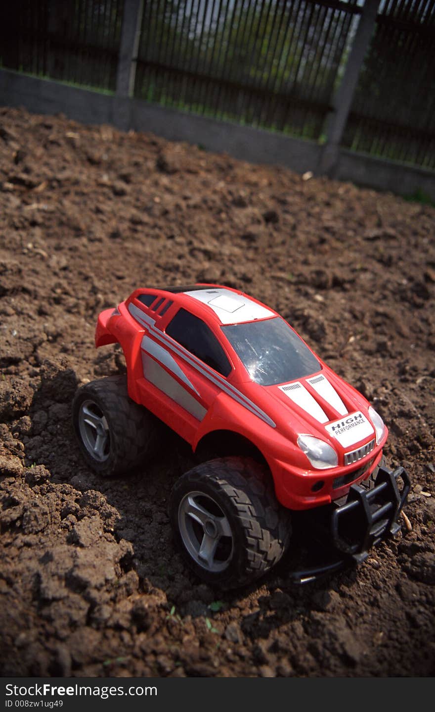 Toy off-road car on ground with slight vignette. Film scan.