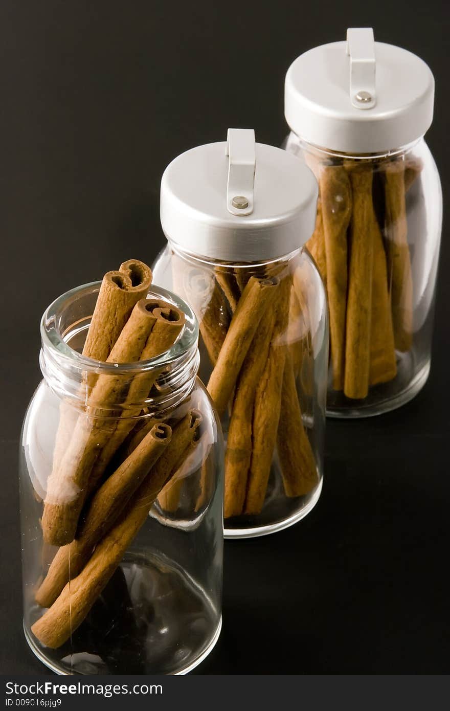 Cinnamon sticks in glass pots, studio shot, close up