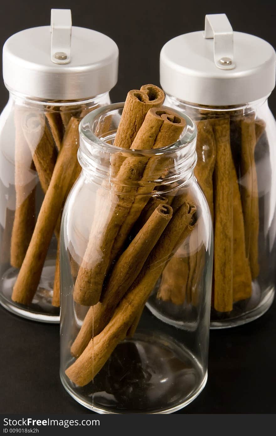 Cinnamon sticks in glass pots, studio shot, close up