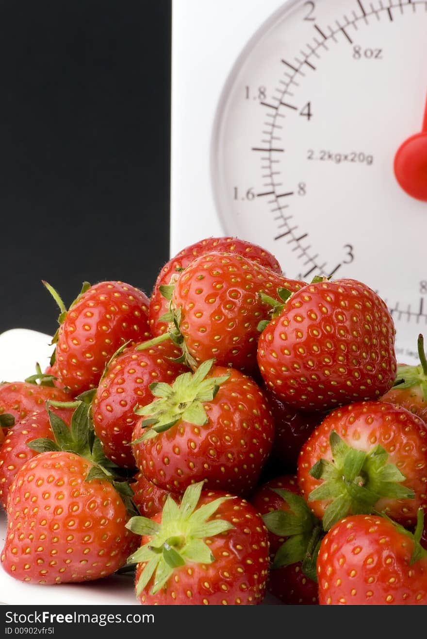 Ripe Strawberry's with Weight Scales shot against a plain background.