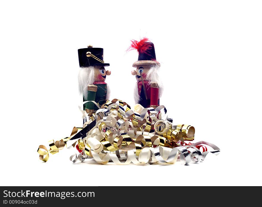 Two christmas nutcrackers with colorful seasonal streamers isolated against a white background. Two christmas nutcrackers with colorful seasonal streamers isolated against a white background.